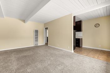 A spacious room with a carpeted floor and a ceiling fan.